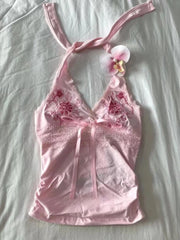 Pink lace babydoll dress with floral embroidery on a light gray background