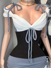 Mannequin wearing a black and white outfit with bow details.