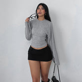 Woman wearing a gray long-sleeve top and black skirt