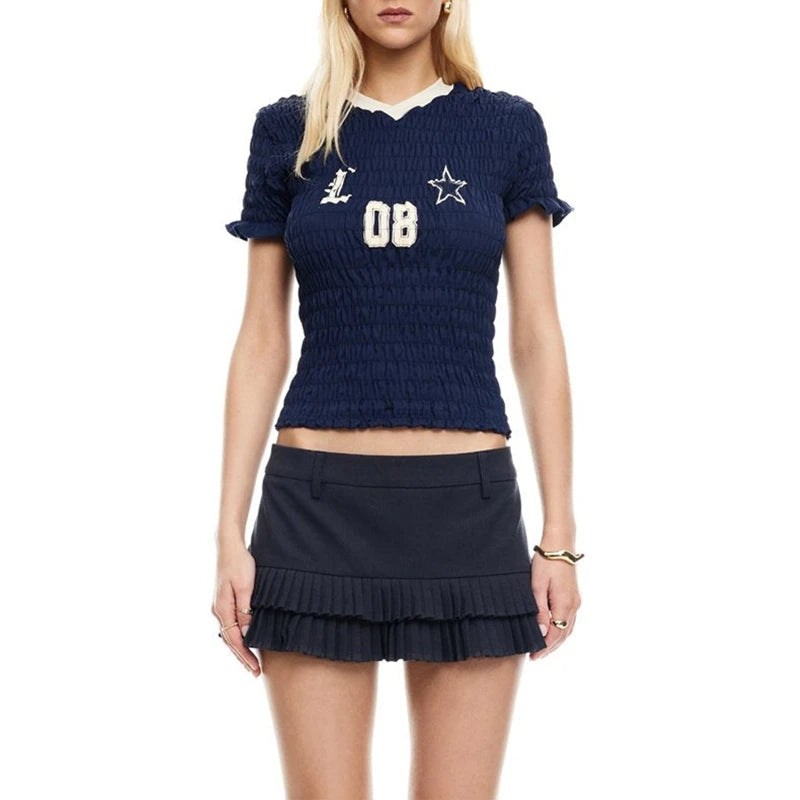 Woman wearing a navy blue textured top and skirt with white lettering on a white background