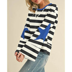 Person wearing a black and white striped sweater with blue star designs on a beige background
