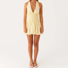 Woman wearing a yellow halter dress - full view