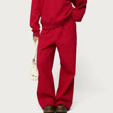 Person wearing a red outfit with wide-leg pants on a light gray background