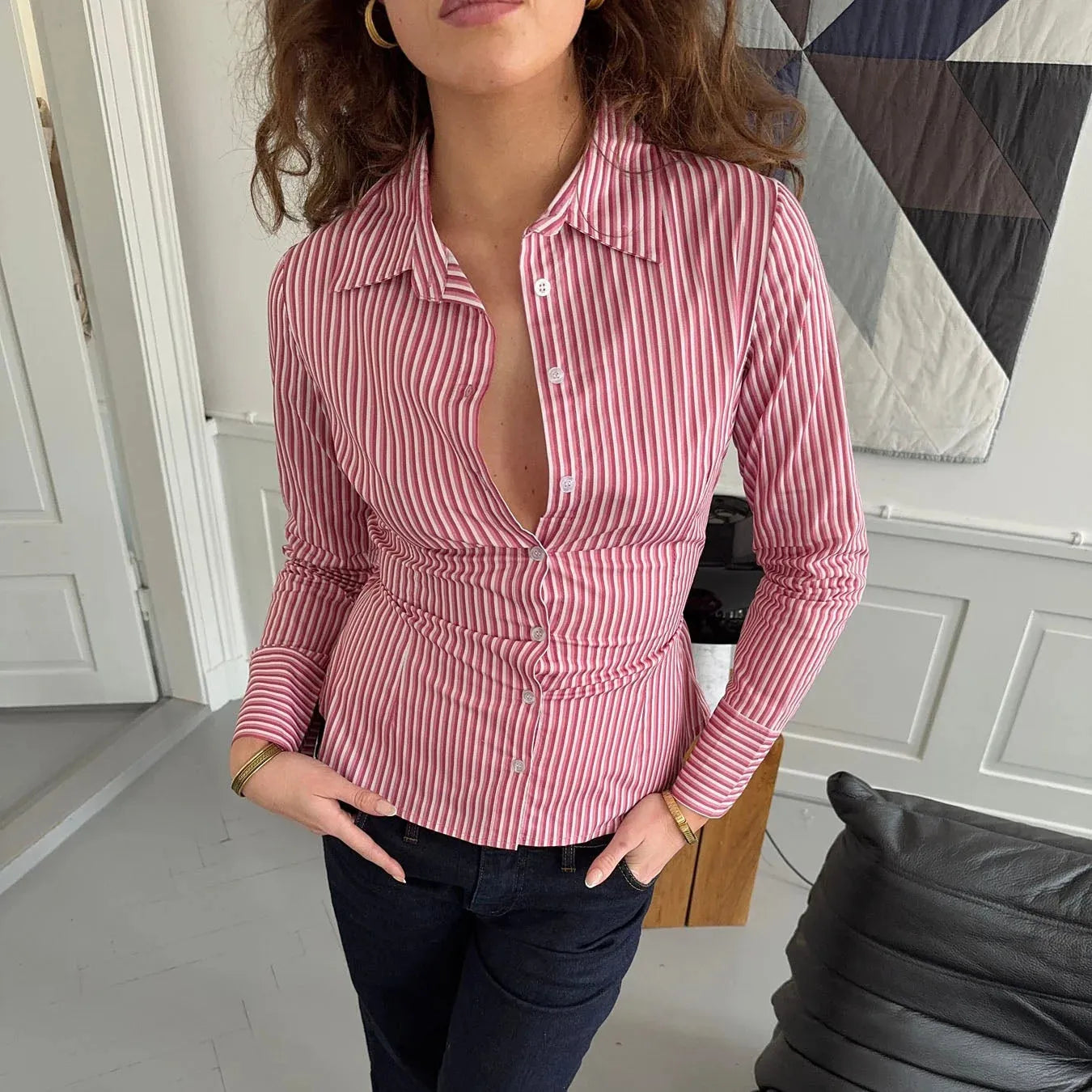 Woman wearing a red and white striped shirt with a geometric pattern in the background