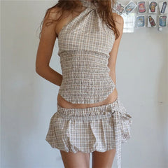 Woman wearing a checkered dress against a plain background