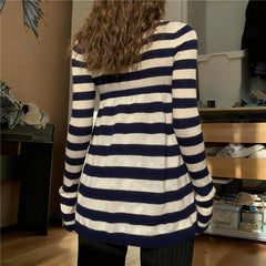 Person wearing a navy and white striped sweater in an indoor setting
