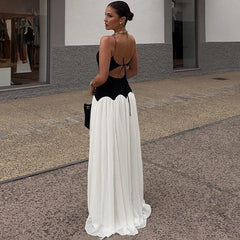 Woman wearing a black and white dress standing on a street.