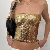Gold sequin strapless top worn by a person with a black handbag