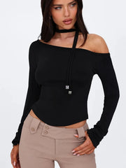 Woman wearing a black off-shoulder top and beige pants
