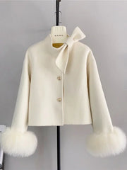 White coat with fur cuffs on a mannequin against a gray background
