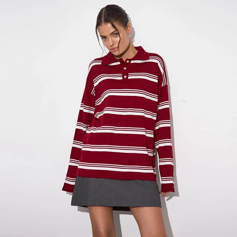 Woman wearing a red and white striped sweater over a gray skirt on a white background