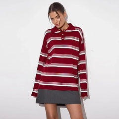 Woman wearing a red and white striped sweater over a gray skirt on a white background