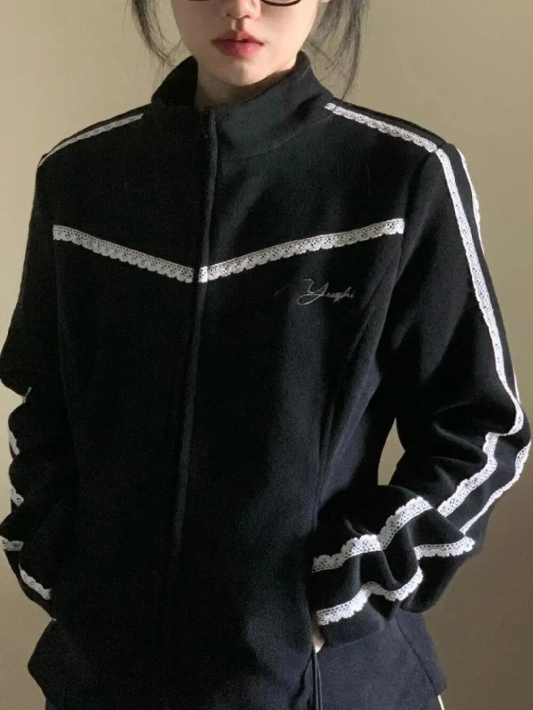 Black tracksuit with white stripes on a neutral background