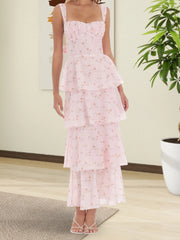 Woman wearing a pink floral dress in a room with a plant and light-colored floor.