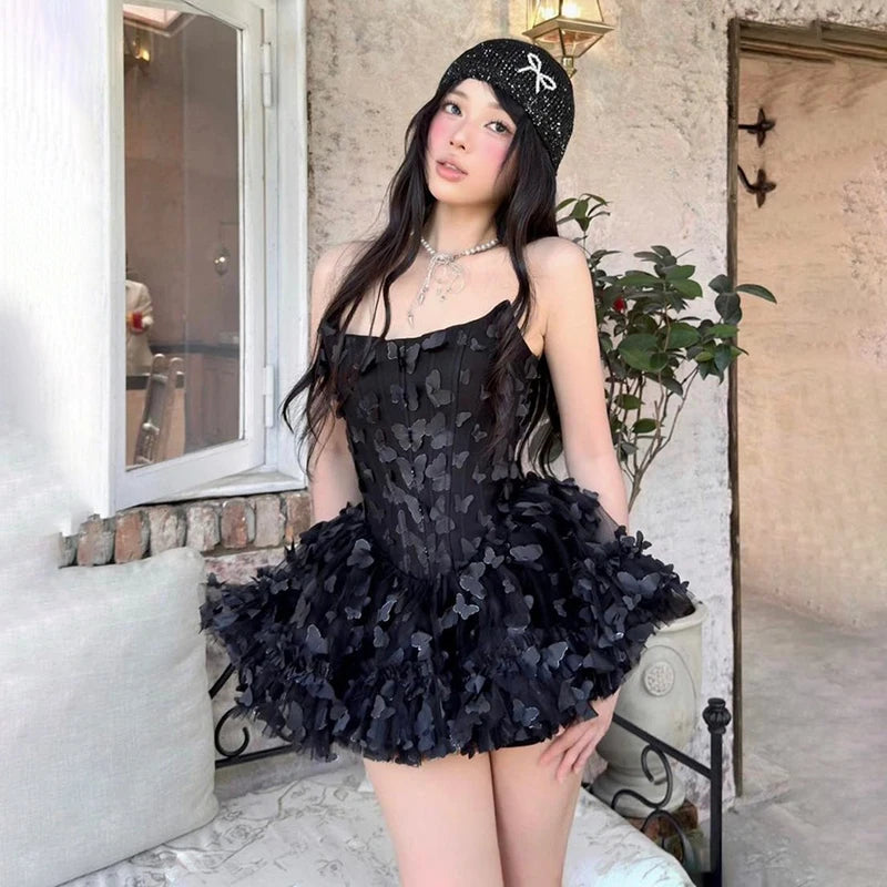 Women's black strapless mini dress with a fitted bodice and a voluminous, layered ruffled skirt.