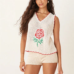 Woman wearing a white sleeveless top with a red rose design on a plain background