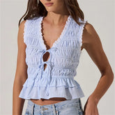 Light blue ruffled top worn by a person on a plain background