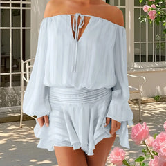 Woman wearing a light blue off-shoulder dress with a floral background