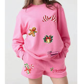 Pink Christmas-themed sweatshirt and shorts set with gingerbread man, candy canes, and bells