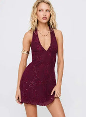 Woman wearing a burgundy lace dress on a plain background