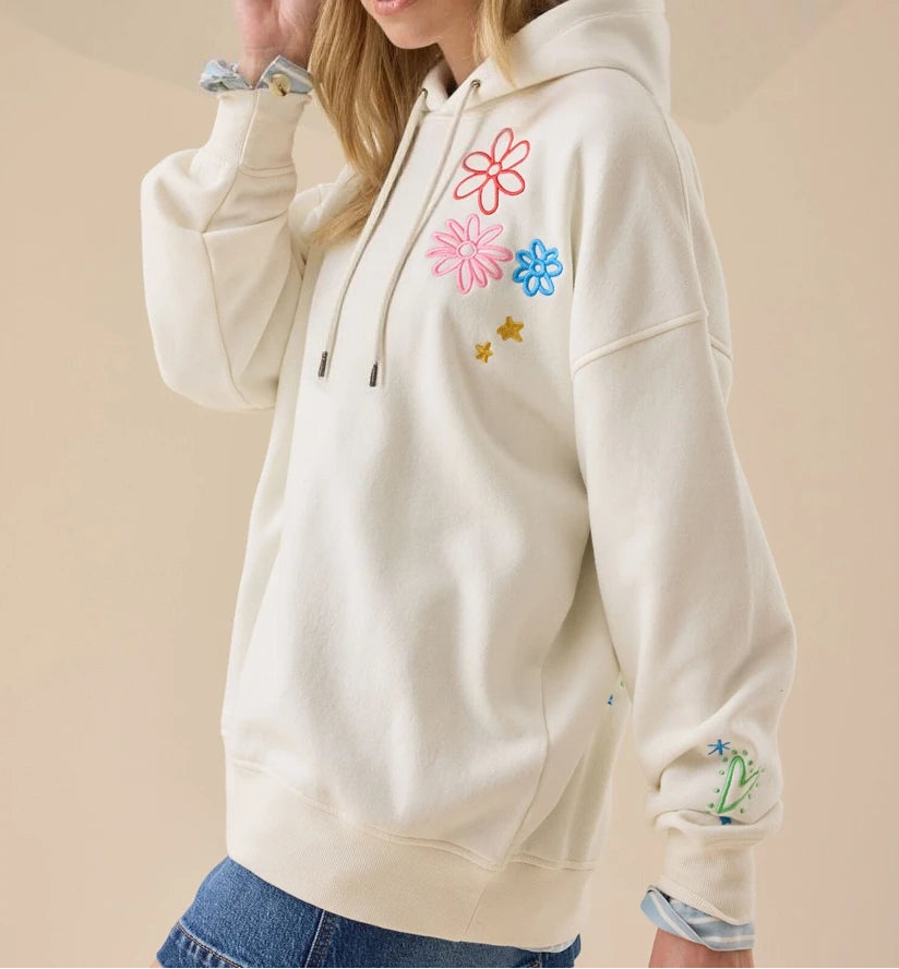 Beige hoodie with colorful floral designs on a beige background