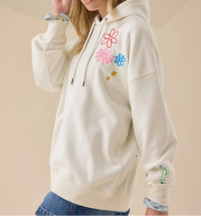 Beige hoodie with colorful floral designs on a beige background