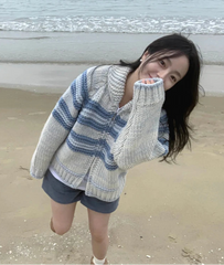Woman wearing a striped sweater on a beach