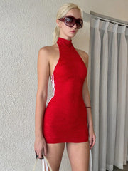 Woman wearing a red dress and sunglasses against a neutral background