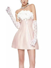 Woman wearing a white strapless dress with floral details and long white gloves