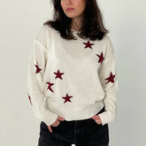 Person wearing a white sweater with red star patterns