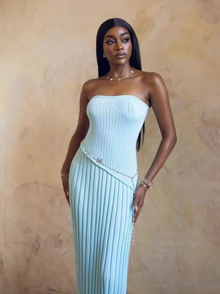 Woman wearing a light blue strapless dress against a beige background