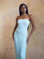 Woman wearing a light blue strapless dress against a beige background