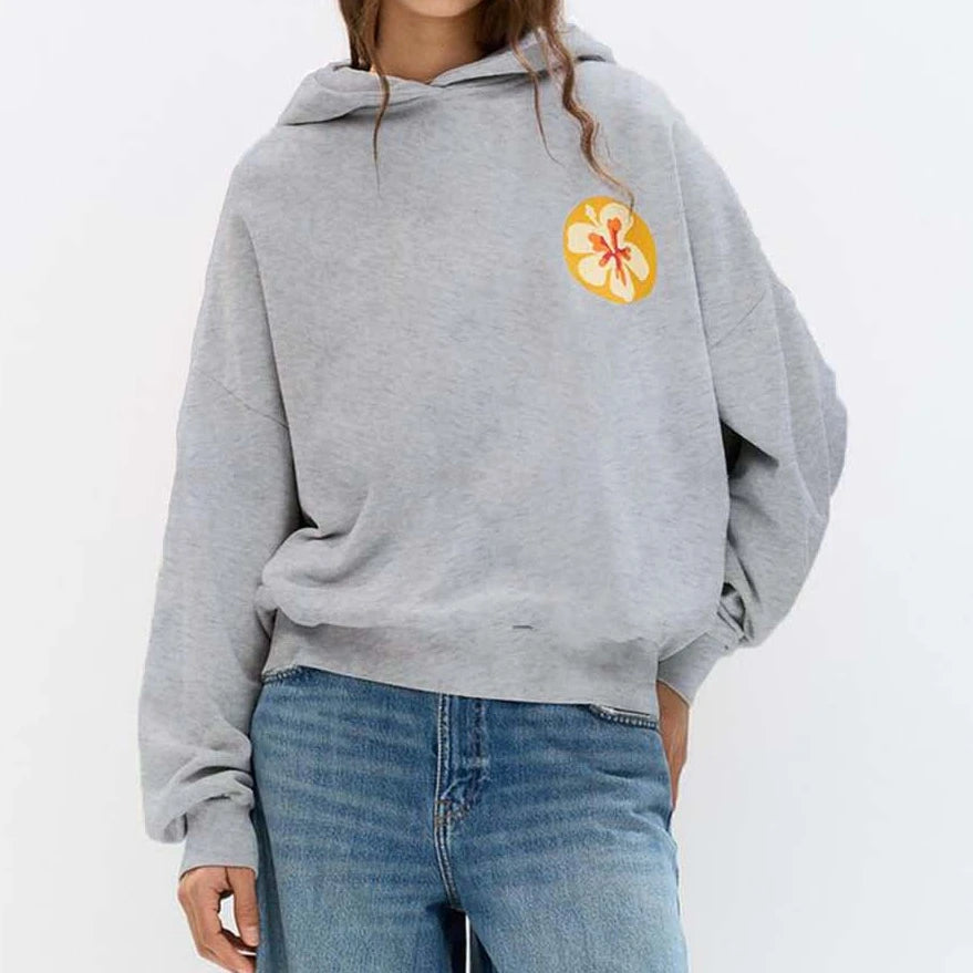 Person wearing a gray hoodie with a colorful flower design