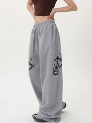 Gray sweatpants with black designs worn by a person