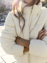 Person wearing a cream-colored knit sweater
