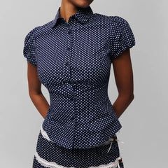 Women's polka dot button down lapel top with puff sleeves.