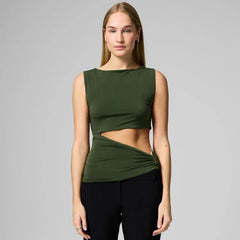 Woman wearing a green sleeveless top and black pants on a gray background