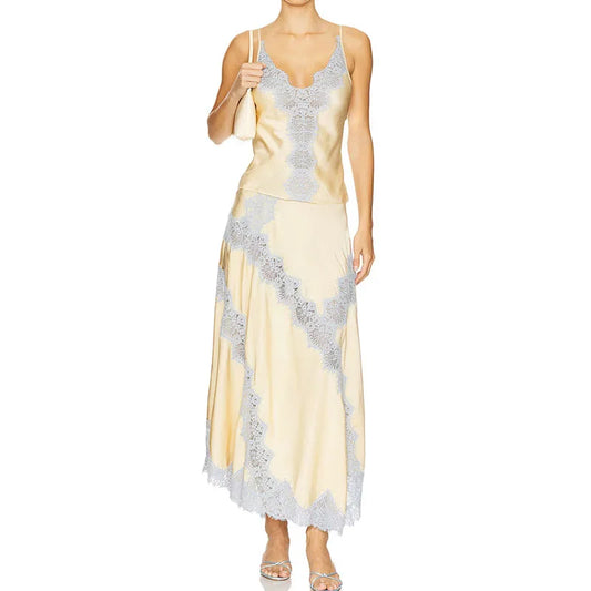 Woman wearing a yellow evening gown with silver lace details on a white background