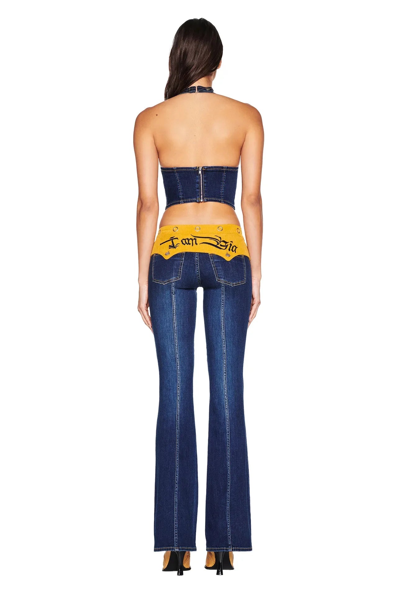 Woman wearing a denim outfit with a visible brand logo on a white background