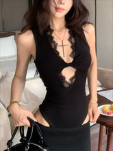 Woman wearing a black dress with cut-out design in a bedroom setting