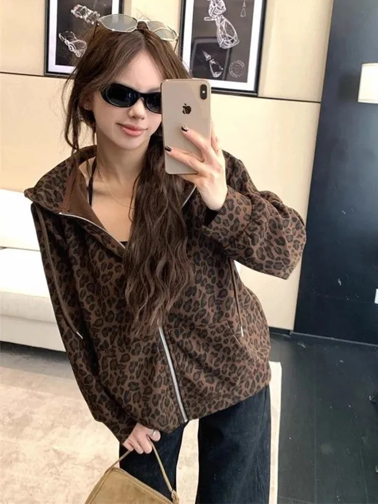 Woman taking a mirror selfie wearing a leopard print jacket.