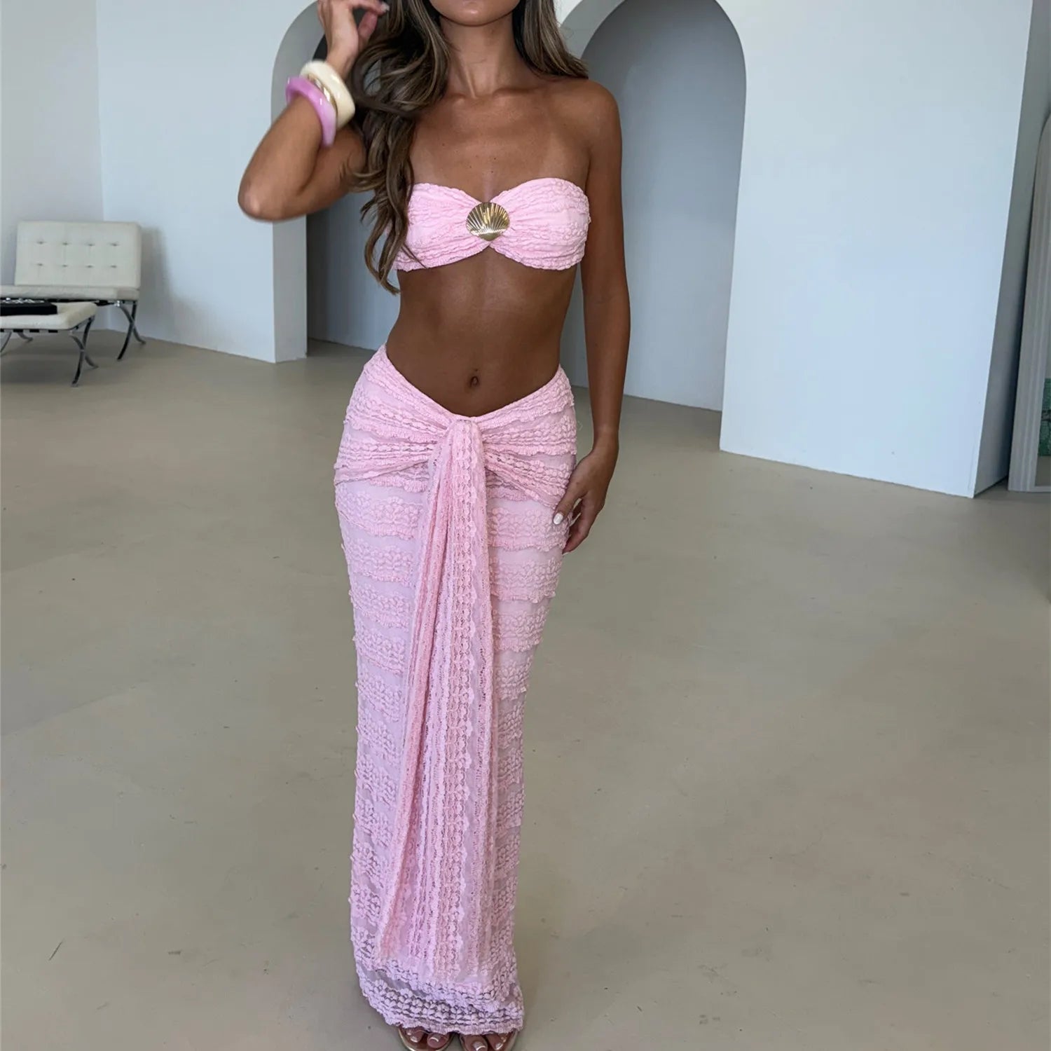 Woman wearing a pink strapless top and sarong in an indoor setting