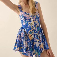 Woman wearing a blue floral dress against a beige background