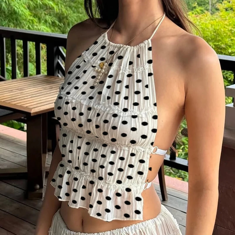 Woman wearing a white polka dot dress with a blurred background