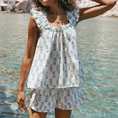 Woman wearing a floral dress standing by a body of water