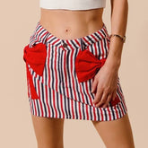 Red, white, and blue striped skirt with red bow pockets on a beige background