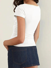 Person wearing a white t-shirt and blue denim skirt- back