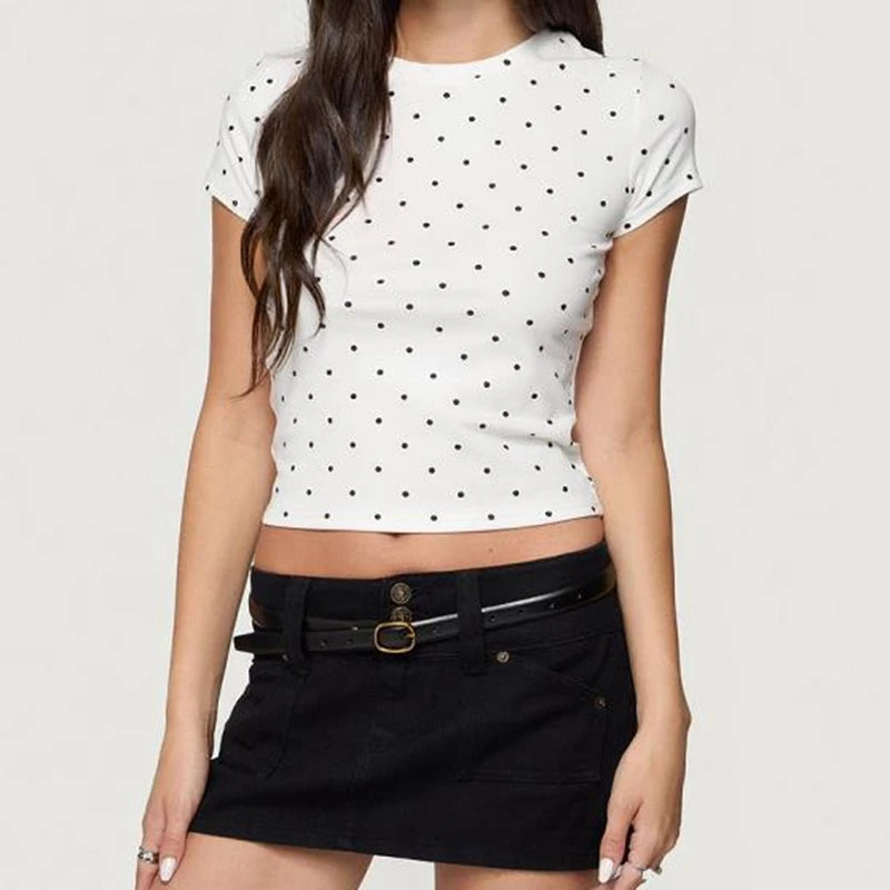 Woman wearing a white polka dot crop top and black skirt