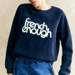 Navy blue sweatshirt with 'french enough' text worn by a person