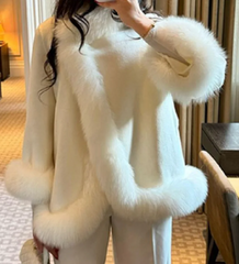 White fur coat with fluffy sleeves worn by a person indoors.